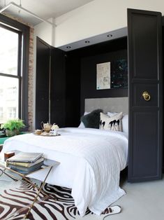 a bedroom with black and white decor, zebra print rugs and a large bed