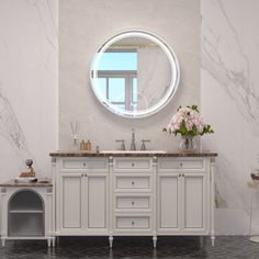 a white bathroom with marble counter tops and a round mirror