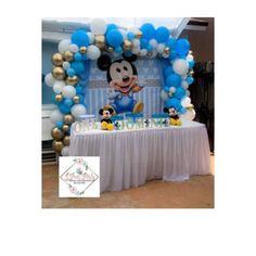 a mickey mouse balloon arch with blue and white balloons on it's sides, along with other decorations