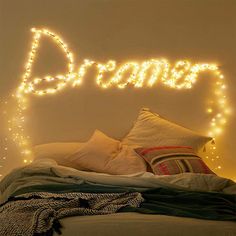 a bed with lights on the headboard above it that says,'dream '