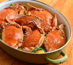 cooked crabs in a pot on a wooden table