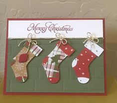 three christmas stockings hanging on a brick wall