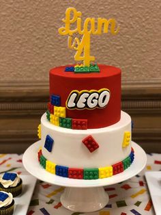 a lego themed birthday cake with cupcakes on the table