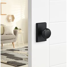 an open door with a black knob on the side and a white wall behind it