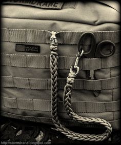 a black and white photo of a pair of scissors in a bag with rope attached to it