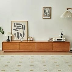 a living room with a white rug and some pictures on the wall next to it