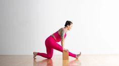 a woman in pink is doing yoga on the floor