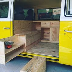 the interior of a yellow van with wooden steps and storage area on the front door