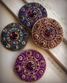 four beaded coasters sitting on top of a window sill