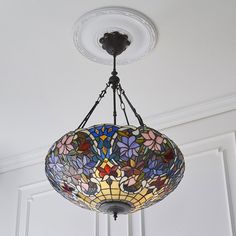 a chandelier hanging from the ceiling with colorful stained glass flowers on it's side