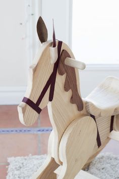 a wooden rocking horse on top of a rug