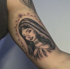 a woman's leg with a tattoo on it that has the image of mary