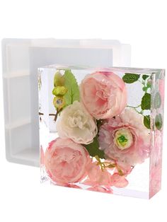 a glass block with pink flowers in it