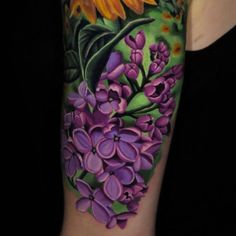 a woman's arm with flowers and leaves painted on the back of her body