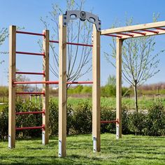 a wooden structure with metal bars in the grass