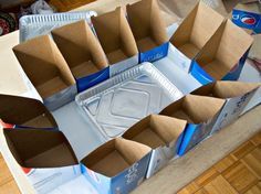 several empty boxes sitting on top of a wooden table with soda cans in the middle