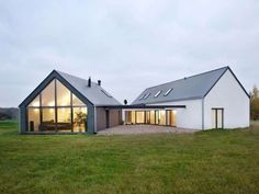 a white house sitting on top of a lush green field next to a grass covered field