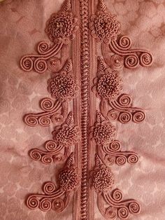 the back of a pink dress with an intricate design on it