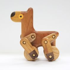 a wooden toy horse with wheels on it's back and one foot in the shape of a dog