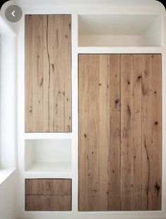 an empty room with wood paneling on the walls and shelves in front of it