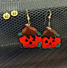 the earrings are decorated with pumpkins and jack - o'- lantern faces on them