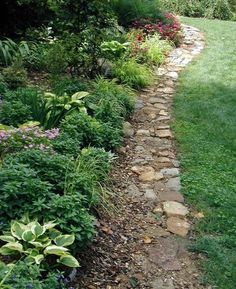 a stone path in the middle of a garden