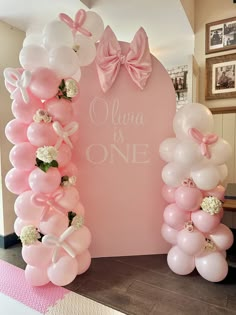 balloons are arranged in the shape of an arch with flowers and bows on it for a baby shower