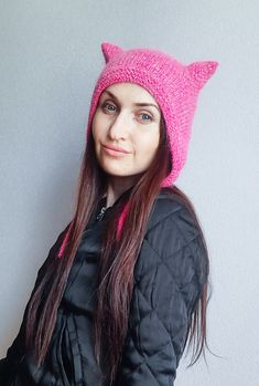 a woman wearing a pink knitted cat hat