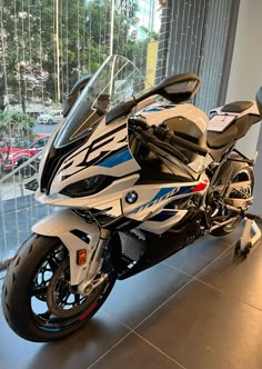 a white and blue motorcycle parked in front of a window