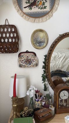 there is a mirror, clock and other items on the table in this room with white walls