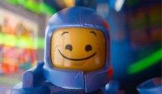 a close up of a lego figure with a smile on his face and arms,