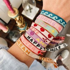 een pols met fel gekleurde armbandjes van lint met tekst. La vie est belle, happy, shine en amour. Happy Sisters, Preppy Accessories, Text Love, Colorful Tapestry, Preppy Jewelry, Ribbon Bracelets, Diy Bracelet Designs, Diy Bracelets Patterns, Summer Bracelets