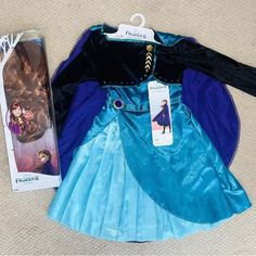 a frozen princess costume next to an unopened doll