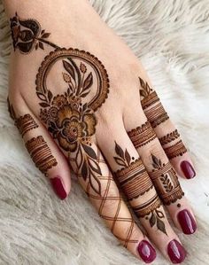 a woman's hand with henna tattoos on it