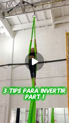 a woman is doing aerial acrobatic tricks in the gym with green ribbons