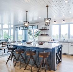 a large kitchen with an island in the middle and lots of counter space on one side