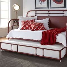 a bed with red and white pillows on it