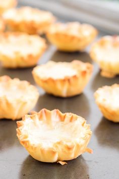 small pies lined up on a baking sheet ready to be baked in the oven