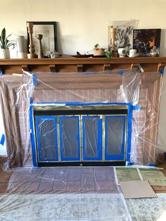 a living room with a fireplace covered in plastic