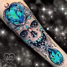 a skull tattoo with blue crystals on it's arm and the face is made up of