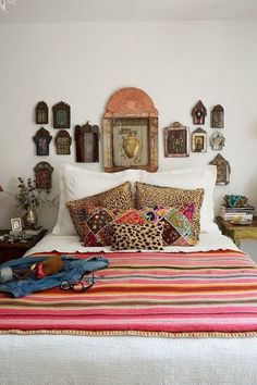 a bedroom with a bed, pillows and pictures on the wall