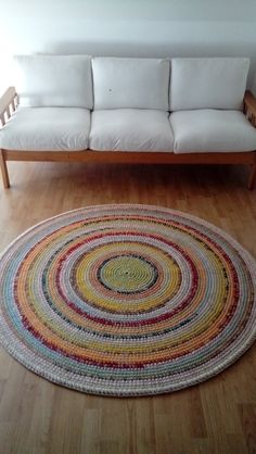 a white couch sitting on top of a hard wood floor next to a wooden table