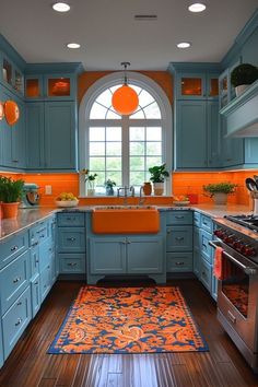 a kitchen with blue cabinets and orange accents on the counter tops, along with an area rug that matches the hardwood flooring