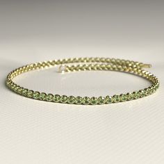 This 1.97 Carat Peridot Dainty Tennis Bracelet in 14K gold is a stunning homage to the August birthstone. Handcrafted with precision, its vibrant green peridot stones are set in a delicate design, perfect for any occasion. Whether stacked or worn alone, this customizable bracelet makes a thoughtful birthday gift for her. Elevate her jewelry collection with this timeless, elegant piece, meticulously designed for sophistication and style. 𝐅𝐞𝐚𝐭𝐮𝐫𝐞𝐬: * 𝐌𝐚𝐝𝐞 𝐭𝐨 𝐎𝐫𝐝𝐞𝐫 * 𝐌𝐞𝐭𝐚𝐥: Dainty Peridot Yellow Gold Jewelry, Classic Peridot Birthstone Jewelry, Luxury Peridot Bracelets For Gifts, Green Peridot Bracelet Jewelry, Green Peridot Round Bracelets, Stacked Wedding Rings, Birthstone Bracelet, August Birthstone, Delicate Design