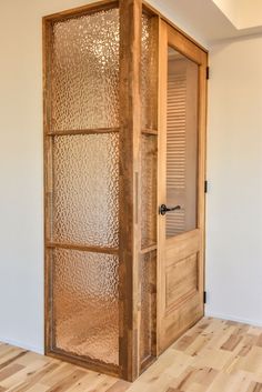 an empty room with a glass door and wooden floor