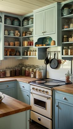 a kitchen filled with lots of green cabinets and wooden counter top space next to an oven