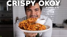 a man holding a plate full of food with the caption crispy okoy