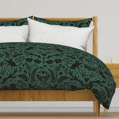 a bed with green and black bedspread, pillows and pillowcases on it