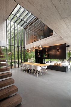 an open floor plan with glass walls and stairs leading up to the upper level area