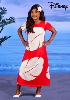 a woman in a red and white dress standing on the beach with her hands on her hips